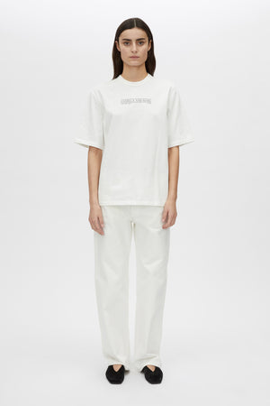 Person wearing a white t-shirt and pants on a white background