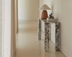 Marble console table with ocean toned veining and sleek design, placed in an entrance hallway.